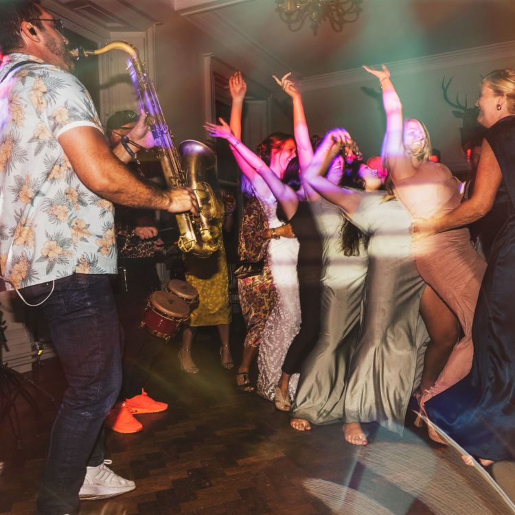 Paul Haywood (Paulonsax) performing live saxophone with Love DeluxX at a wedding reception at Scorrier House, Cornwall. The bride and guests fill the dance floor, celebrating with an energetic sax & DJ wedding set.